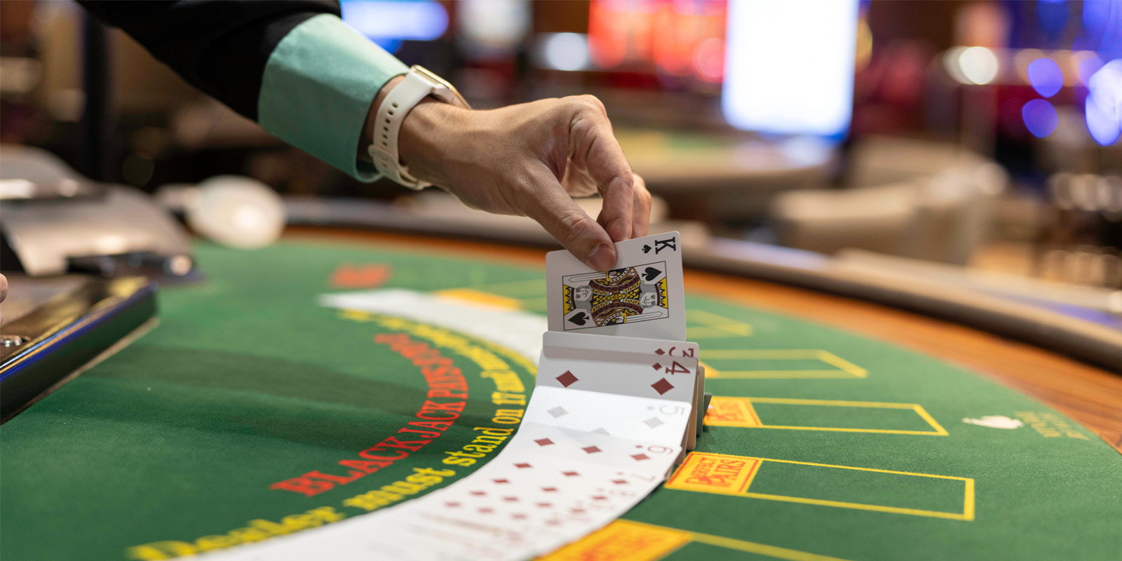 Dealer placing the cards down on the table game green felt area
