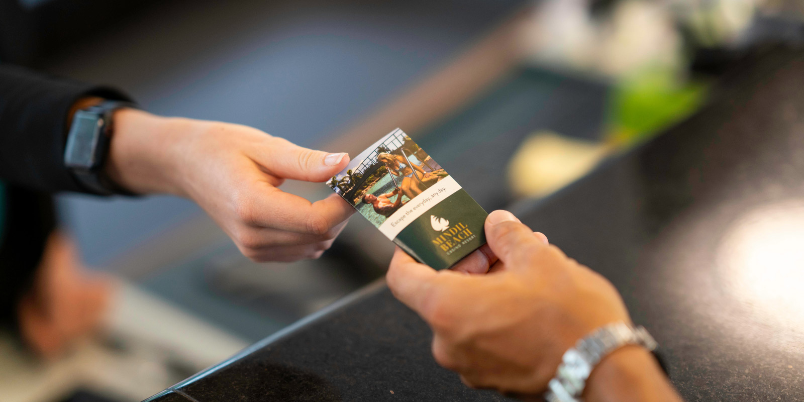 Person handing a hotel key to a guest